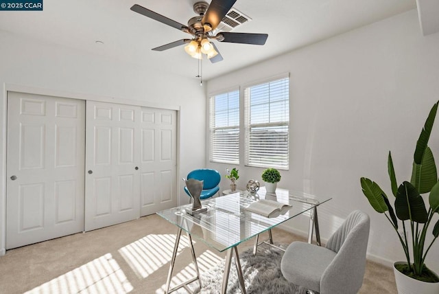 carpeted office space featuring ceiling fan