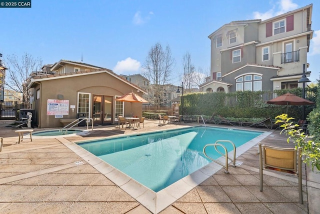 view of pool featuring a hot tub and a patio area