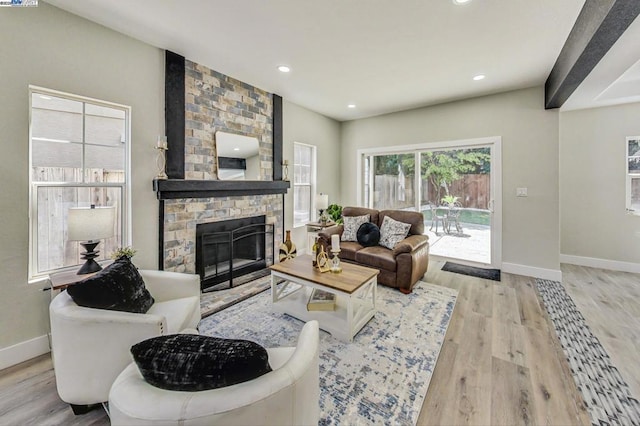 living room featuring a brick fireplace and light hardwood / wood-style flooring