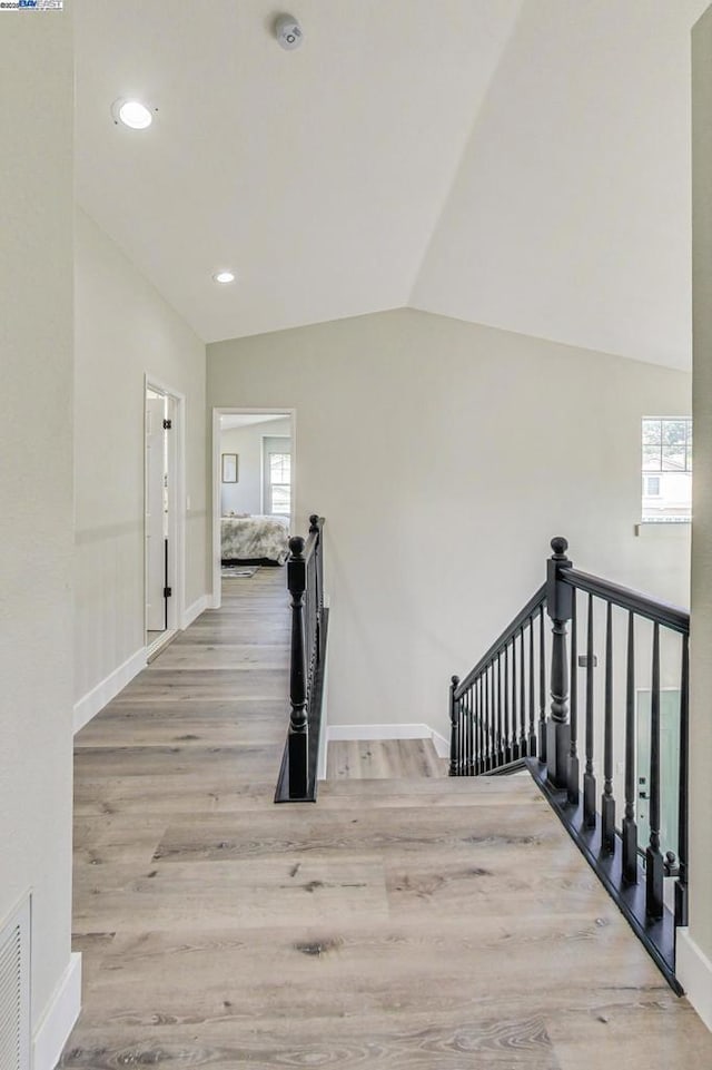 stairs with lofted ceiling and hardwood / wood-style floors