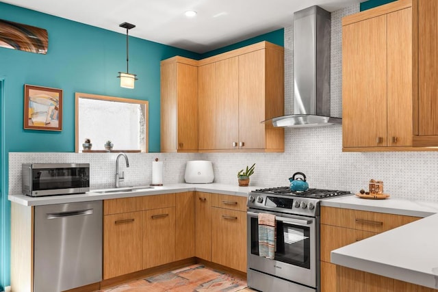 kitchen with backsplash, wall chimney range hood, sink, hanging light fixtures, and appliances with stainless steel finishes