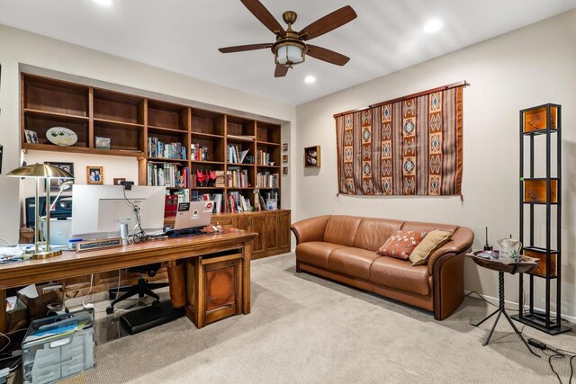 carpeted home office featuring ceiling fan