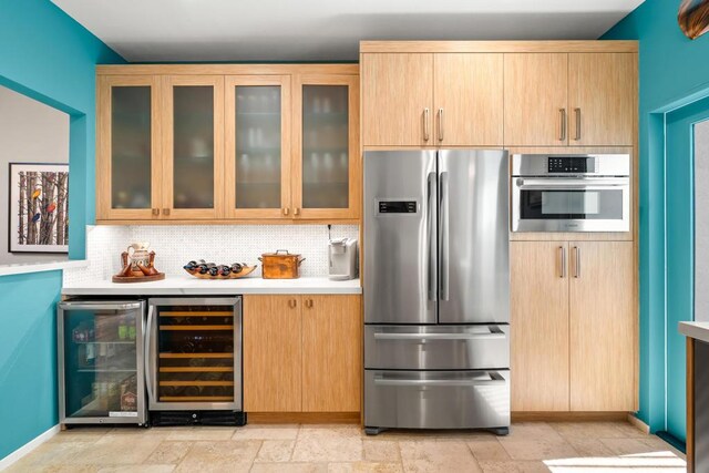 kitchen featuring wine cooler, appliances with stainless steel finishes, light brown cabinets, and tasteful backsplash