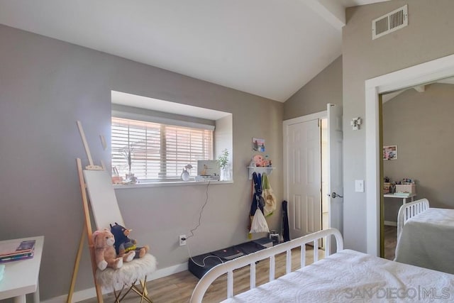 bedroom with lofted ceiling and wood-type flooring