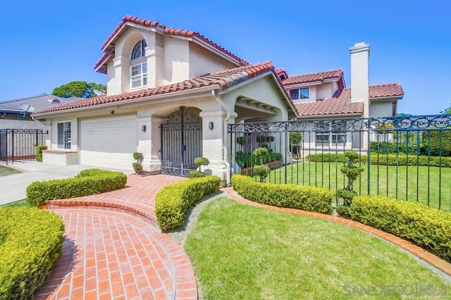 mediterranean / spanish home with a front lawn and a garage