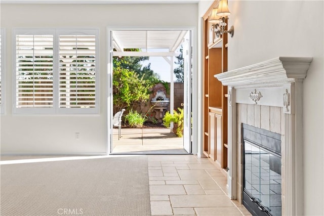 doorway with a tile fireplace and plenty of natural light