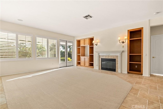 unfurnished living room with a fireplace and built in features