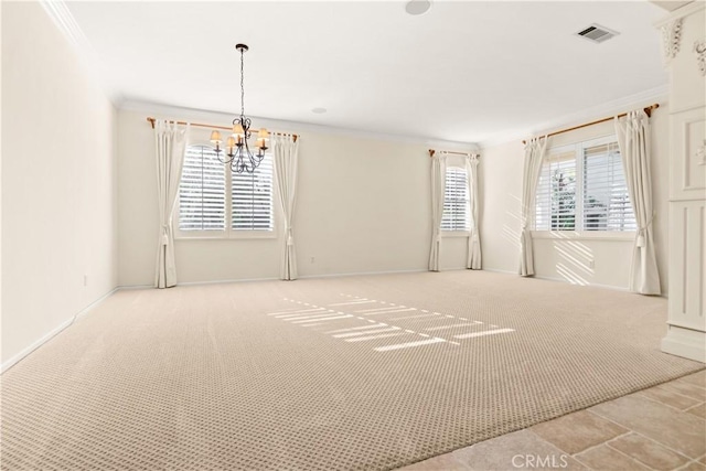 carpeted empty room featuring crown molding and a notable chandelier