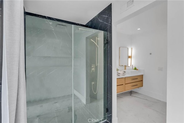 bathroom with tiled shower and vanity