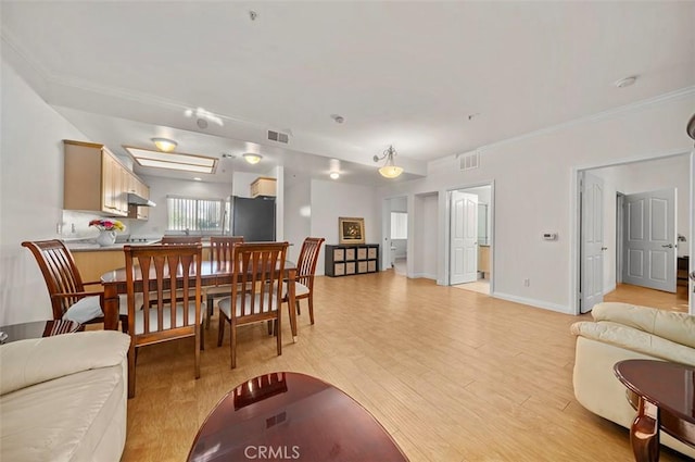 dining room featuring crown molding and light hardwood / wood-style floors