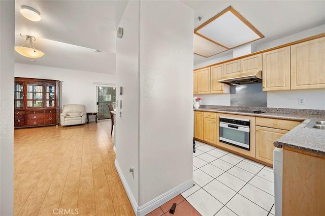 kitchen featuring pendant lighting, light brown cabinets, black electric stovetop, sink, and stainless steel oven