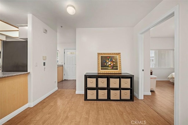 hall with a wealth of natural light and light hardwood / wood-style flooring