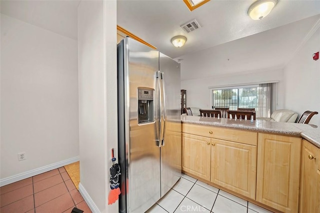 kitchen featuring kitchen peninsula, stainless steel refrigerator with ice dispenser, light tile patterned flooring, and light brown cabinets