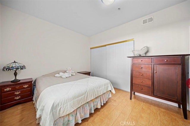 bedroom with a closet and light hardwood / wood-style flooring