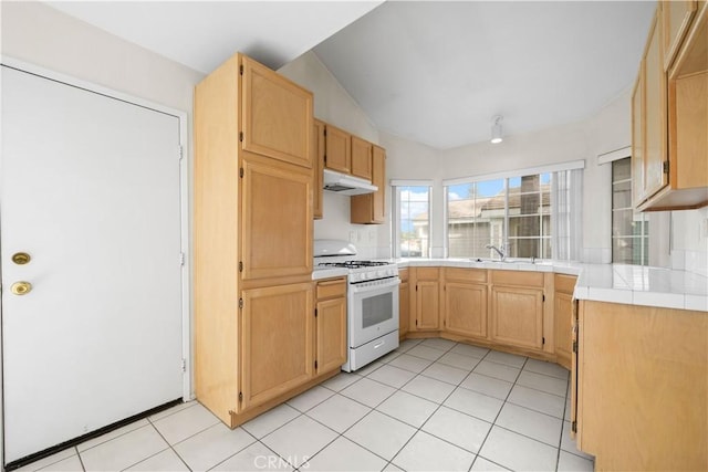 kitchen featuring light brown cabinets, sink, white gas range, tile countertops, and light tile patterned floors