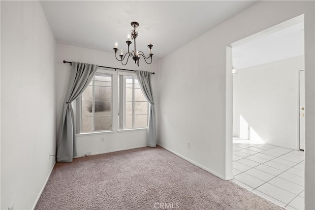 carpeted spare room featuring a notable chandelier