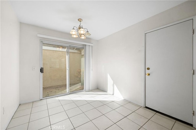 spare room with a notable chandelier and light tile patterned flooring