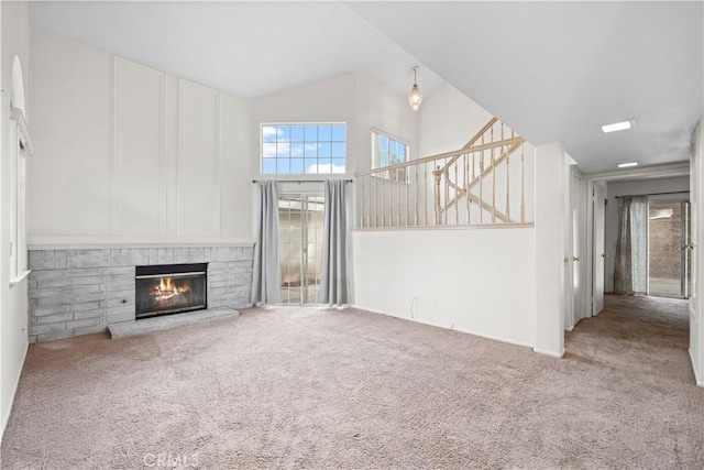 unfurnished living room with a brick fireplace, carpet, and high vaulted ceiling