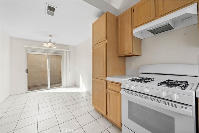 kitchen featuring decorative light fixtures, white range with gas cooktop, tile counters, light tile patterned floors, and a chandelier