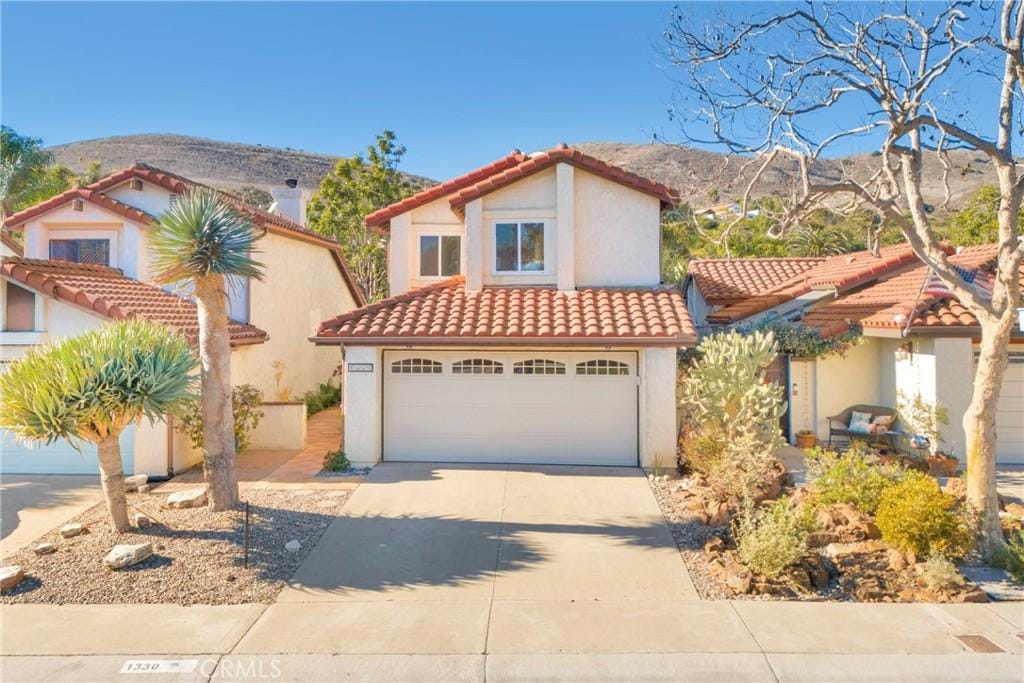 mediterranean / spanish-style house featuring a mountain view and a garage