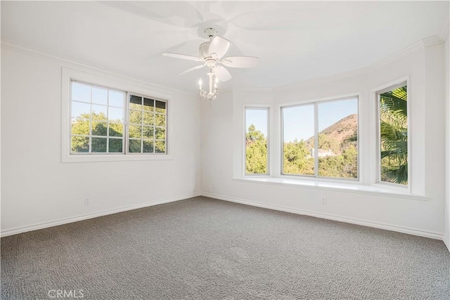 spare room featuring crown molding, ceiling fan, a healthy amount of sunlight, and carpet flooring