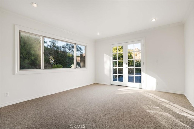 spare room with french doors, crown molding, and carpet