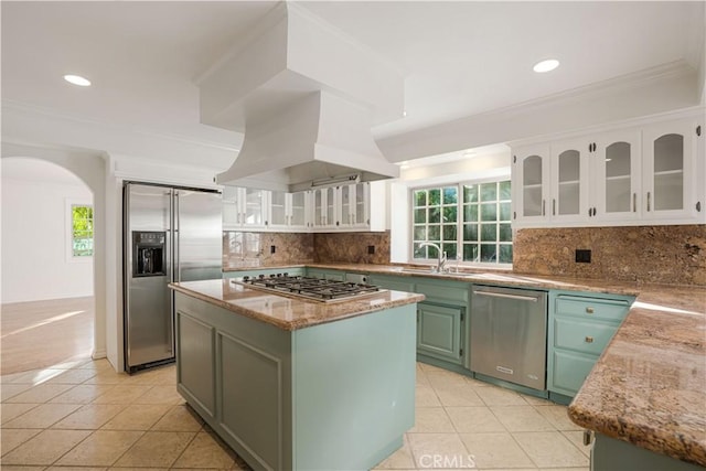 kitchen with a kitchen island, island exhaust hood, appliances with stainless steel finishes, and white cabinets