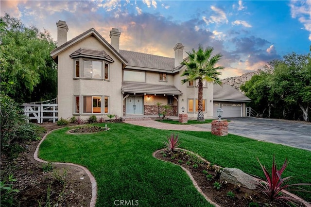 view of front of property with a garage and a lawn