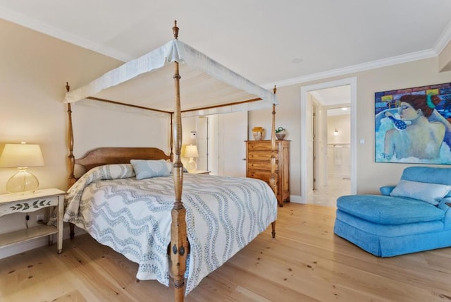 bedroom featuring ornamental molding, connected bathroom, and light hardwood / wood-style floors