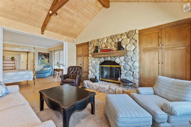 living room featuring beamed ceiling, wood ceiling, a fireplace, and light wood-type flooring