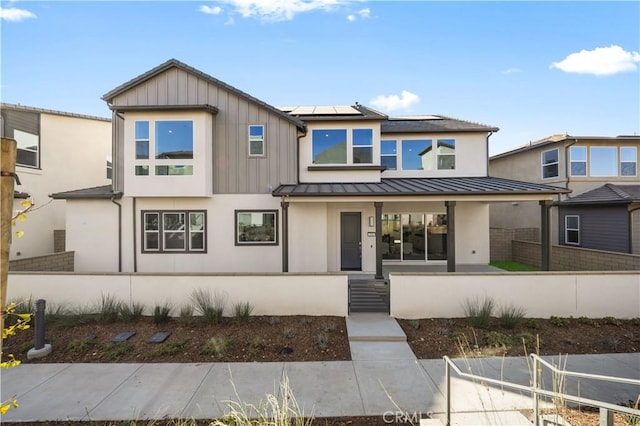 view of front of home with covered porch and solar panels