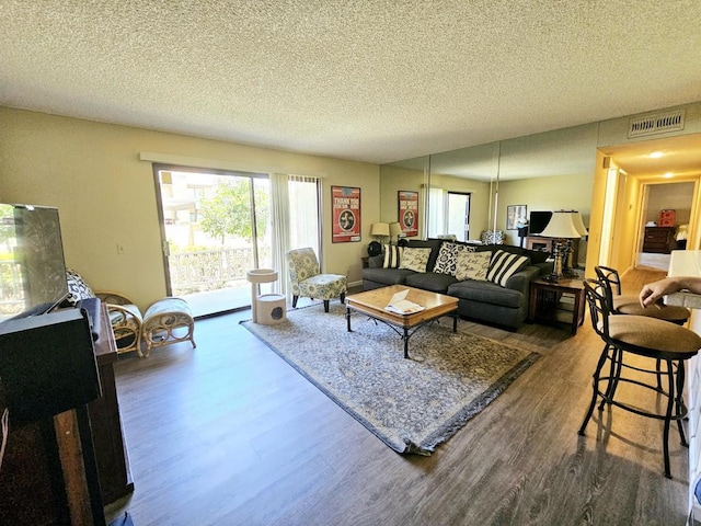 living room featuring a textured ceiling and hardwood / wood-style floors