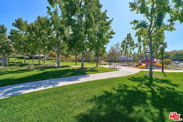 view of property's community featuring a lawn and a playground