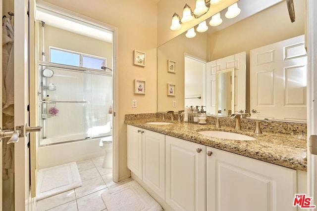 full bathroom featuring toilet, tile patterned flooring, vanity, and shower / bath combination with glass door