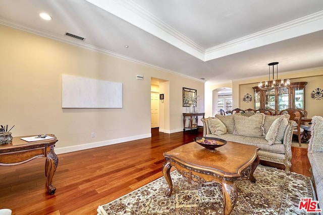 living room with a chandelier, crown molding, and hardwood / wood-style flooring