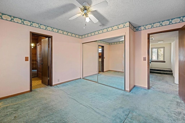 unfurnished bedroom with light carpet, a closet, ceiling fan, and a textured ceiling