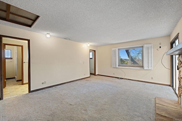 unfurnished living room featuring a textured ceiling, light colored carpet, and a fireplace