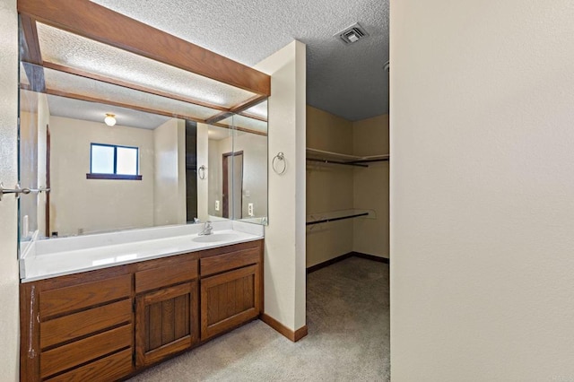 bathroom with a textured ceiling and vanity