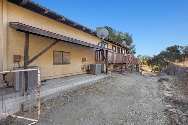 back of property featuring a deck and central AC