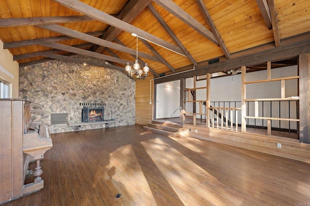 unfurnished living room featuring an inviting chandelier, high vaulted ceiling, beam ceiling, wood-type flooring, and a stone fireplace