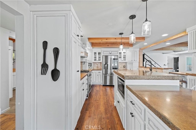 kitchen with white cabinets, decorative light fixtures, stainless steel appliances, decorative backsplash, and dark hardwood / wood-style floors