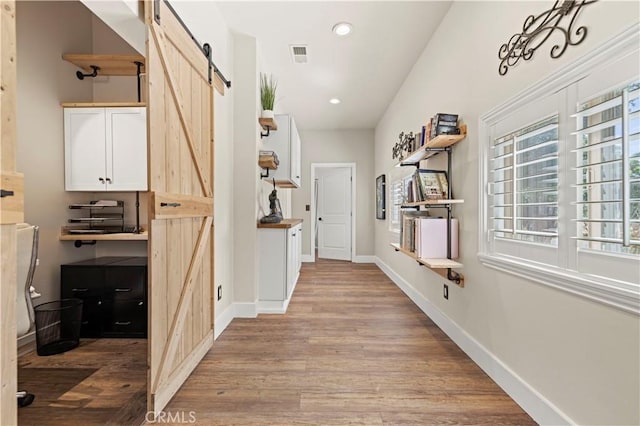 12475 Christmas Tree Rd, Ojai, CA 93023 - corridor featuring baseboards, visible vents, a barn door, and wood finished floors