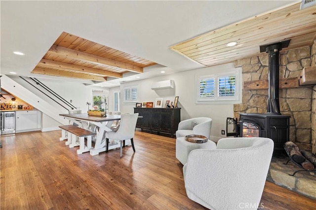 living room with beamed ceiling, wine cooler, a wall unit AC, hardwood / wood-style flooring, and wooden ceiling