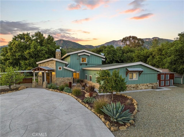 12475 Christmas Tree Rd, Ojai, CA 93023 - view of front of house featuring stone siding, a chimney, a mountain view, and concrete driveway