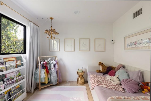 bedroom featuring light hardwood / wood-style floors and a notable chandelier