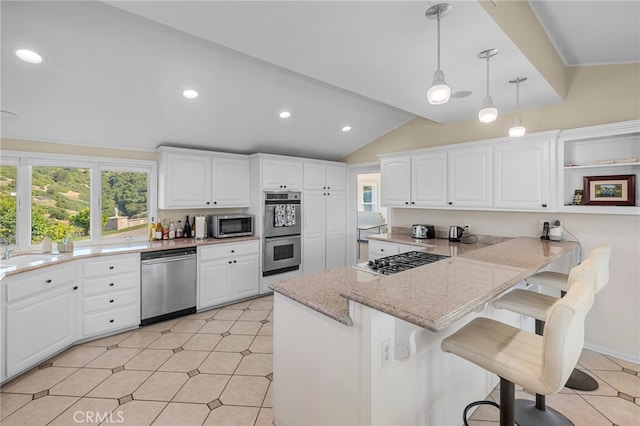 kitchen featuring pendant lighting, white cabinets, stainless steel appliances, kitchen peninsula, and a breakfast bar area