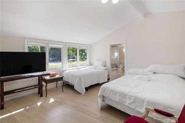 bedroom featuring light wood-type flooring, ensuite bathroom, and vaulted ceiling with beams