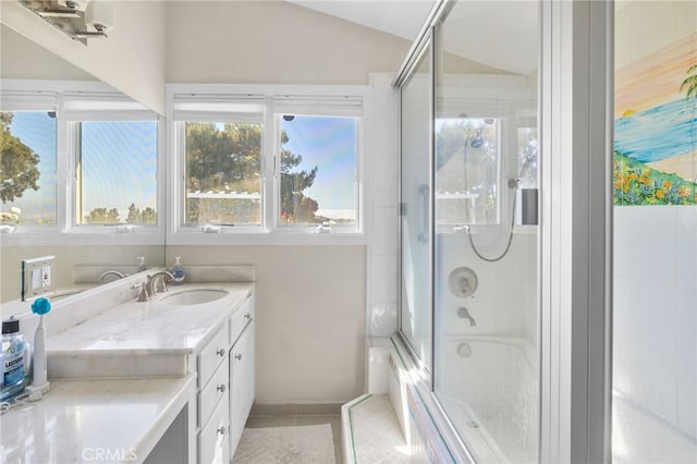 bathroom featuring combined bath / shower with glass door, vanity, and lofted ceiling