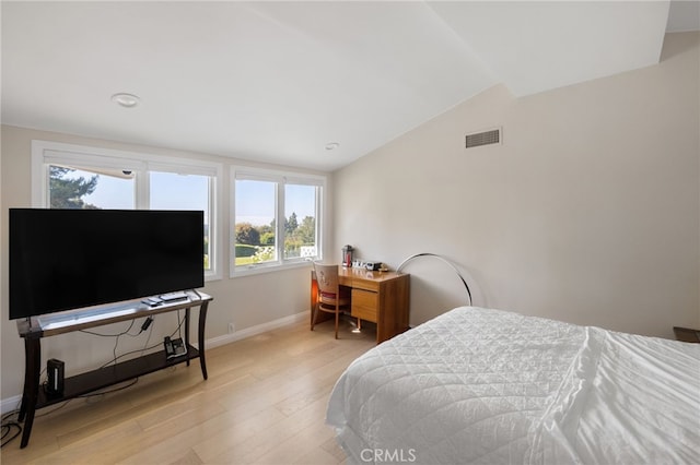 bedroom with light hardwood / wood-style floors and vaulted ceiling