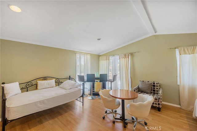 bedroom featuring vaulted ceiling, crown molding, and light hardwood / wood-style flooring